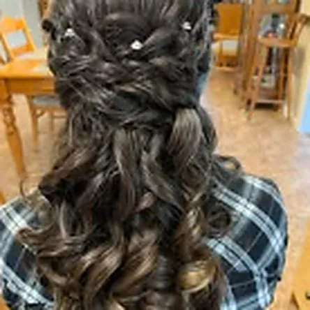 Dark curls pinned into a half-up occasion style